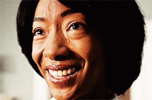 A Woman With A Tear Running Down Her Face Is Smiling GIF