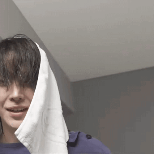 A Woman With A Towel Wrapped Around Her Head Is Smiling GIF