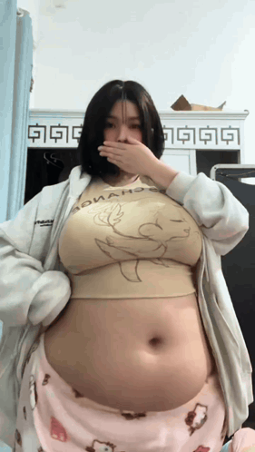 A Woman With A Very Large Belly Is Wearing A Shirt That Says Donald Duck GIF