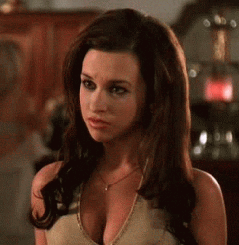 A Woman With A Very Large Breast Is Wearing A Necklace And A Tank Top . GIF