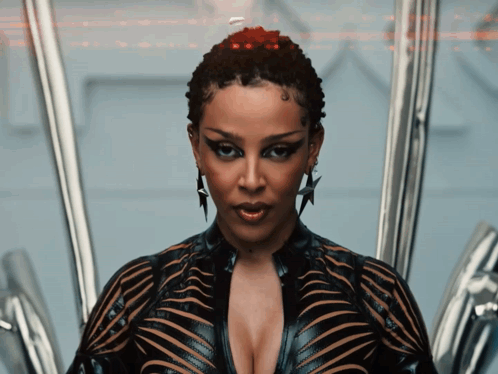 A Woman With A Very Plunging Neckline And A Star Earring Looks At The Camera GIF