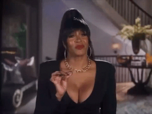 A Woman With A Very Plunging Neckline Is Wearing A Necklace GIF