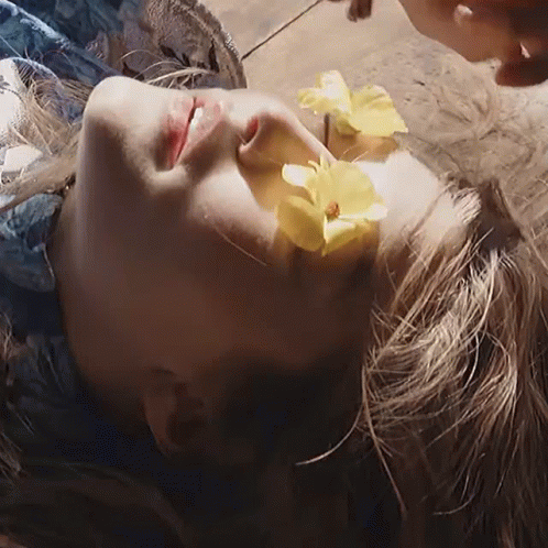 A Woman With A Yellow Flower In Her Hair GIF
