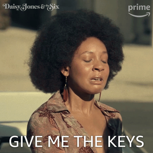 A Woman With An Afro Says Give Me The Keys In Front Of An Amazon Prime Logo GIF