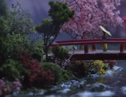 A Woman With An Umbrella Is Walking Across A Bridge GIF