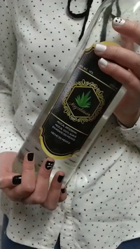 A Woman With Black Nails Holds A Bottle Of Alcohol GIF