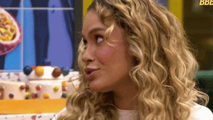 A Woman With Blonde Curly Hair Looks To The Side GIF