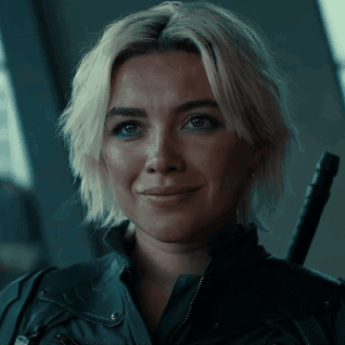 A Woman With Blonde Hair And A Black Jacket Is Smiling GIF