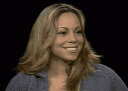 A Woman With Blonde Hair And A Blue Sweater Smiles GIF