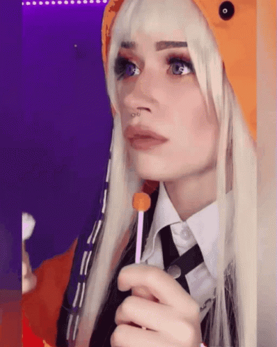 A Woman With Blonde Hair And A Nose Ring Holds A Lollipop In Her Hand GIF