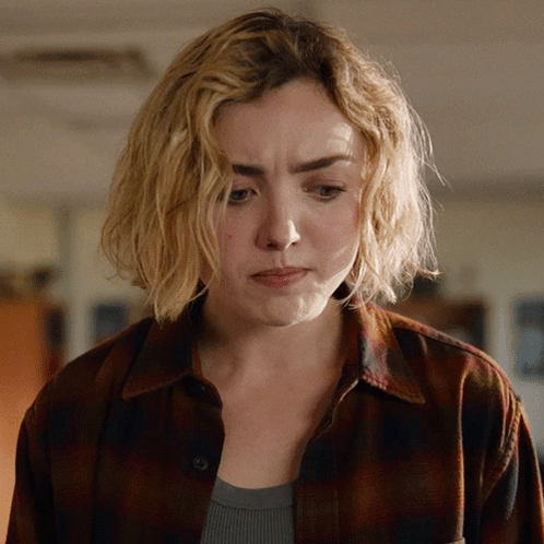 A Woman With Blonde Hair And A Plaid Shirt Looks Sad GIF