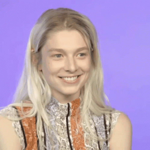 A Woman With Blonde Hair And A Striped Shirt Is Smiling GIF