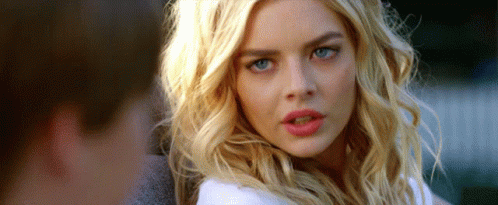 A Woman With Blonde Hair And Blue Eyes Is Looking At The Camera With A Surprised Look On Her Face . GIF