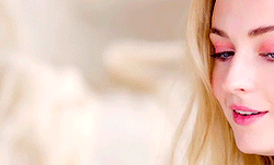 A Woman With Blonde Hair And Blue Eyes Is Smiling GIF