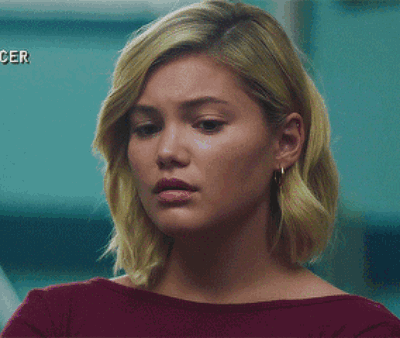 A Woman With Blonde Hair And Earrings Is Wearing A Red Shirt GIF