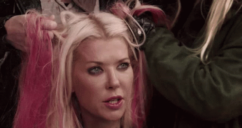 A Woman With Blonde Hair And Pink Highlights Is Getting Her Hair Dyed . GIF