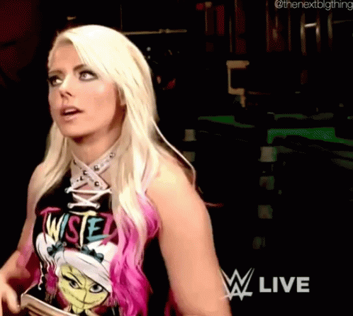 A Woman With Blonde Hair And Pink Highlights Is Wearing A T-Shirt That Says ' Wise ' On It . GIF
