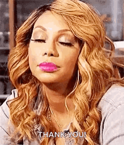 A Woman With Blonde Hair And Pink Lipstick Is Making A Funny Face . GIF