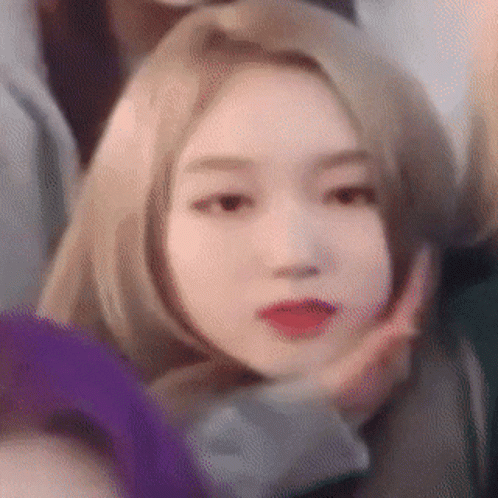 A Woman With Blonde Hair And Red Lips Is Making A Funny Face . GIF