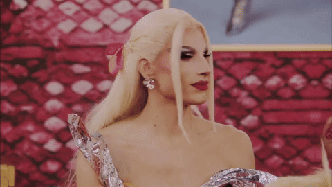 A Woman With Blonde Hair And Red Lipstick Is Wearing A Foil Dress GIF