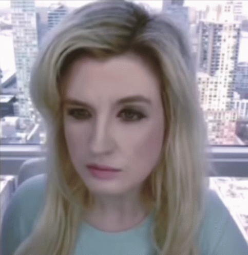 A Woman With Blonde Hair Is Looking At The Camera GIF