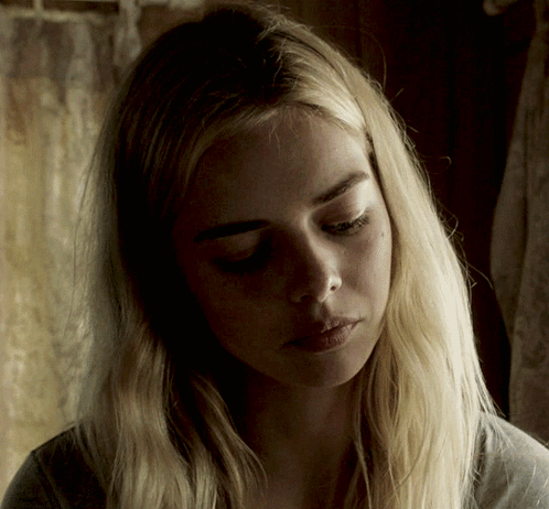 A Woman With Blonde Hair Is Looking Down At Something GIF