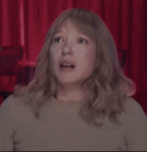 A Woman With Blonde Hair Is Making A Funny Face GIF