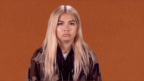 A Woman With Blonde Hair Is Making A Funny Face . GIF