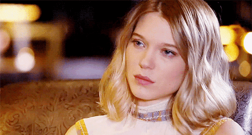 A Woman With Blonde Hair Is Sitting In A Chair GIF