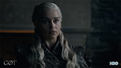 A Woman With Blonde Hair Is Sitting In Front Of A Sign That Says Hbo GIF
