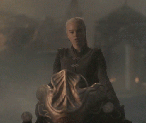 A Woman With Blonde Hair Is Sitting On A Chair GIF