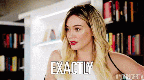 a woman with blonde hair is standing in front of a bookshelf and says exactly .