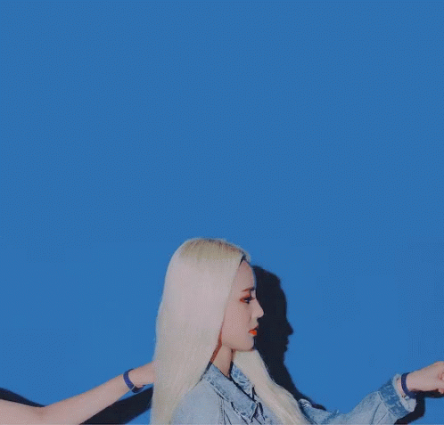 A Woman With Blonde Hair Is Wearing A Blue Denim Jacket GIF
