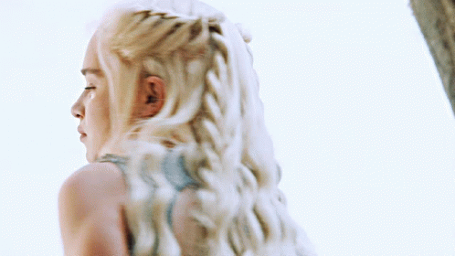 A Woman With Blonde Hair Is Wearing A Blue Top GIF