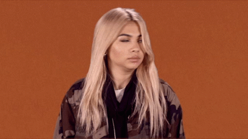 A Woman With Blonde Hair Is Wearing A Camo Jacket And Headphones GIF