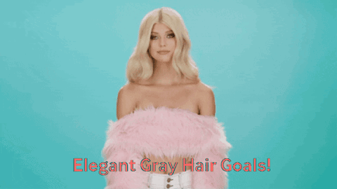 A Woman With Blonde Hair Is Wearing A Pink Fur Coat GIF
