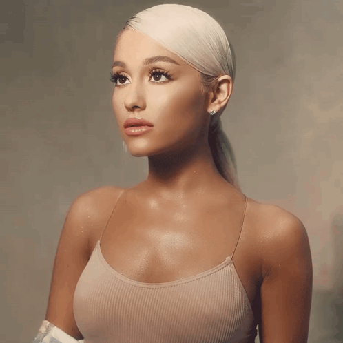 A Woman With Blonde Hair Is Wearing A Tank Top GIF