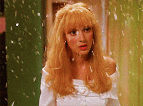 a woman with blonde hair is wearing a white top