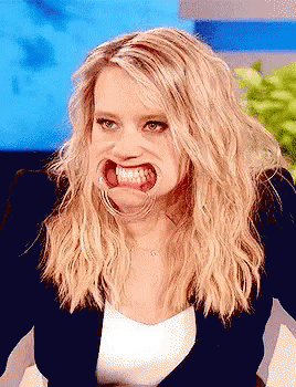 A Woman With Blonde Hair Making A Funny Face With Her Mouth Open GIF