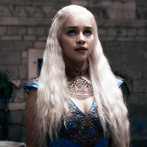 A Woman With Blonde Hair Wearing A Blue And Gold Dress GIF
