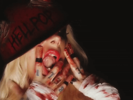 A Woman With Blood On Her Face And A Hat That Says Hell Pop GIF
