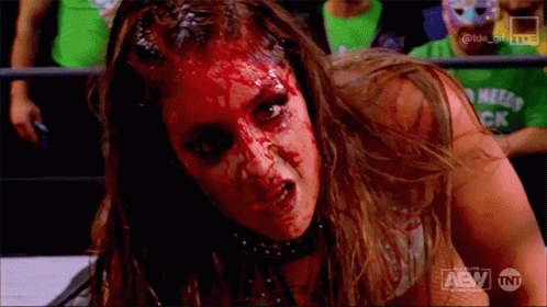 A Woman With Blood On Her Face Is Wearing A Shirt That Says Tnt On It GIF