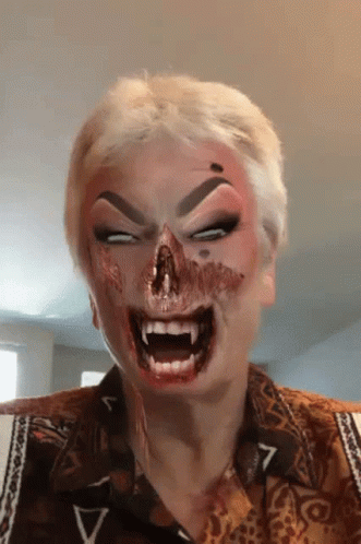 A Woman With Blood On Her Face Is Wearing A Shirt With The Letter V On The Sleeve GIF