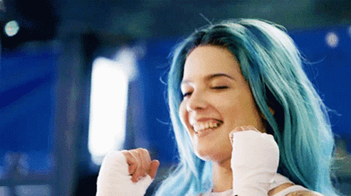 A Woman With Blue Hair And White Gloves Is Smiling And Laughing . GIF