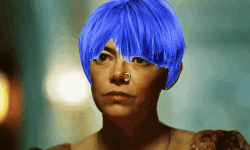 a woman with blue hair has a nose ring on her nose