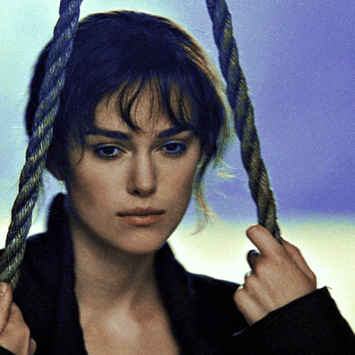 A Woman With Blue Hair Is Holding A Rope Around Her Head GIF