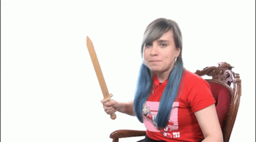 A Woman With Blue Hair Is Holding A Wooden Sword And Wearing A Red Shirt That Says T3 GIF