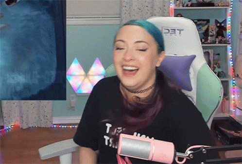A Woman With Blue Hair Is Sitting In A Chair With The Word Det On The Back GIF