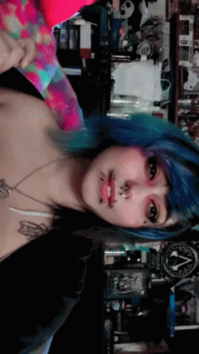 A Woman With Blue Hair Is Standing In Front Of A Sign That Says ' Apocalypse ' GIF