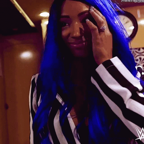 A Woman With Blue Hair Is Wearing A Striped Shirt And A Ring GIF